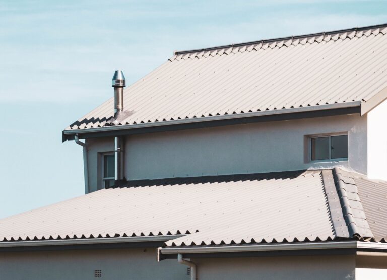 A contemporary house rooftop under a clear blue sky, showcasing architectural design.