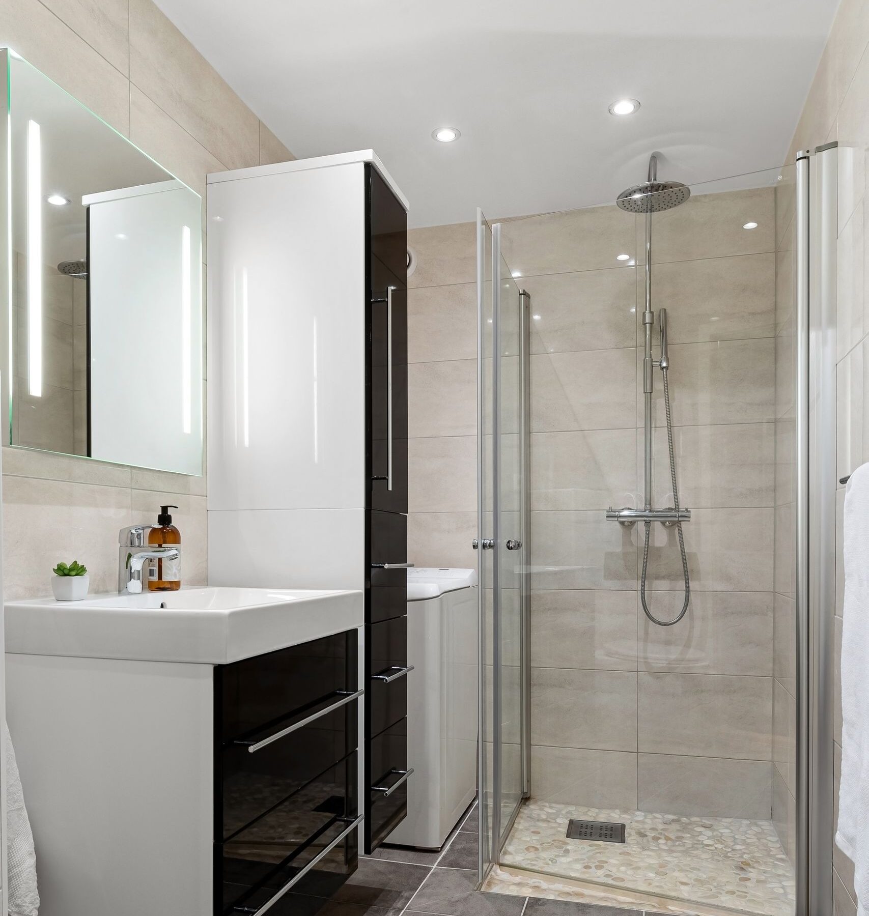 Contemporary bathroom interior featuring sleek glass shower and elegant fixtures.