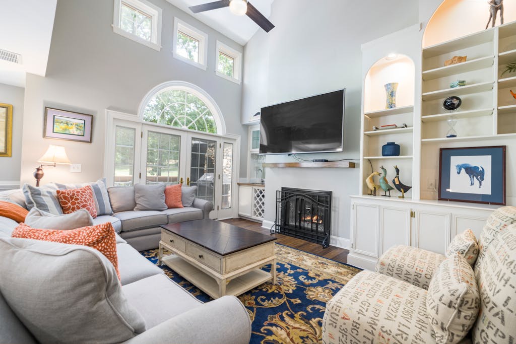 Cozy modern living room featuring a fireplace, large TV, and stylish decor, perfect for relaxation.