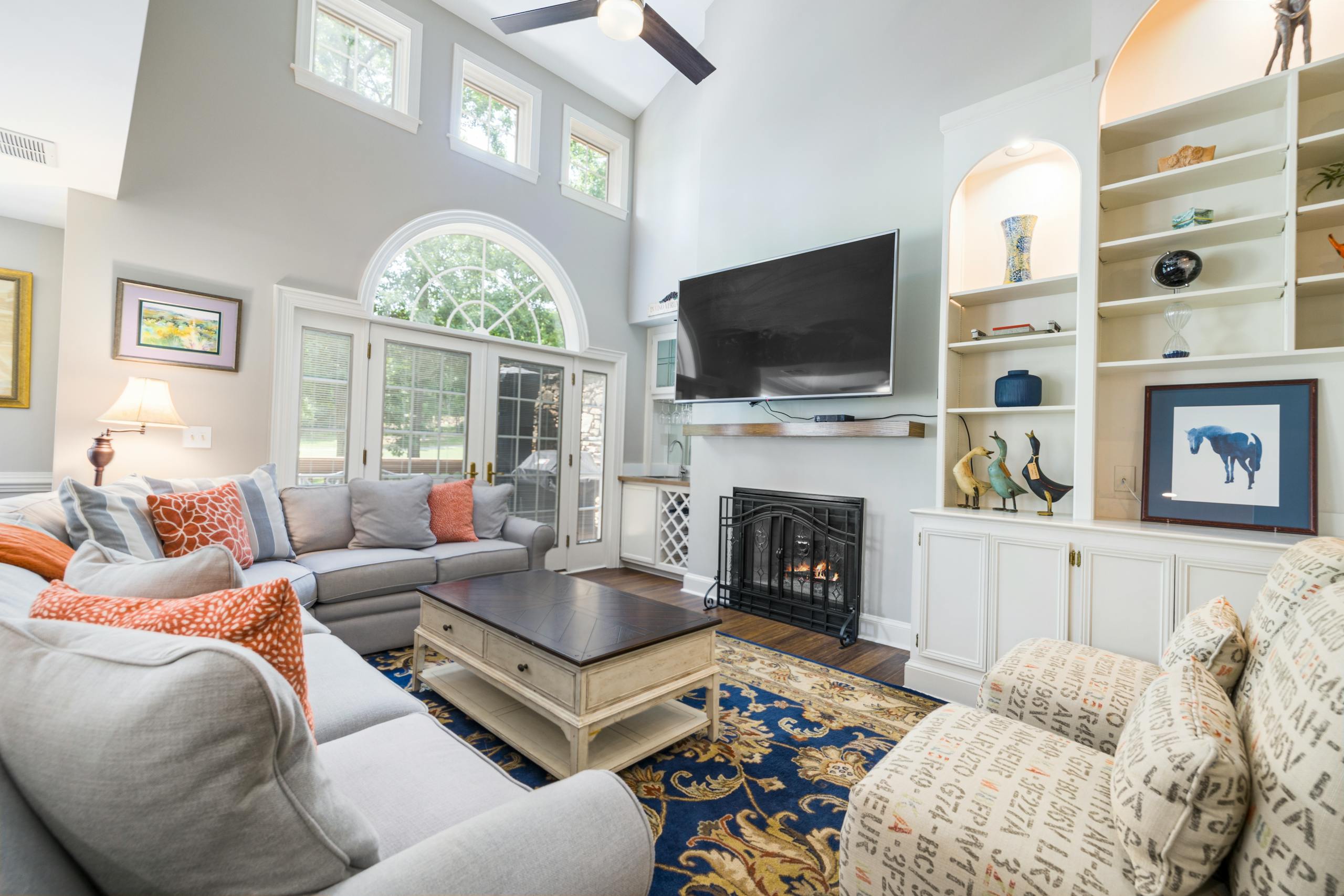 Cozy modern living room featuring a fireplace, large TV, and stylish decor, perfect for relaxation.