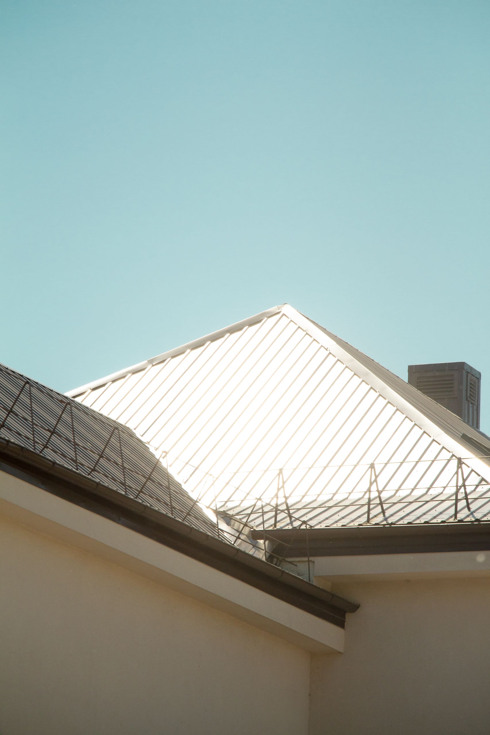 Minimalistic view of a metal roof shining under sunlight, perfect for modern architecture themes.