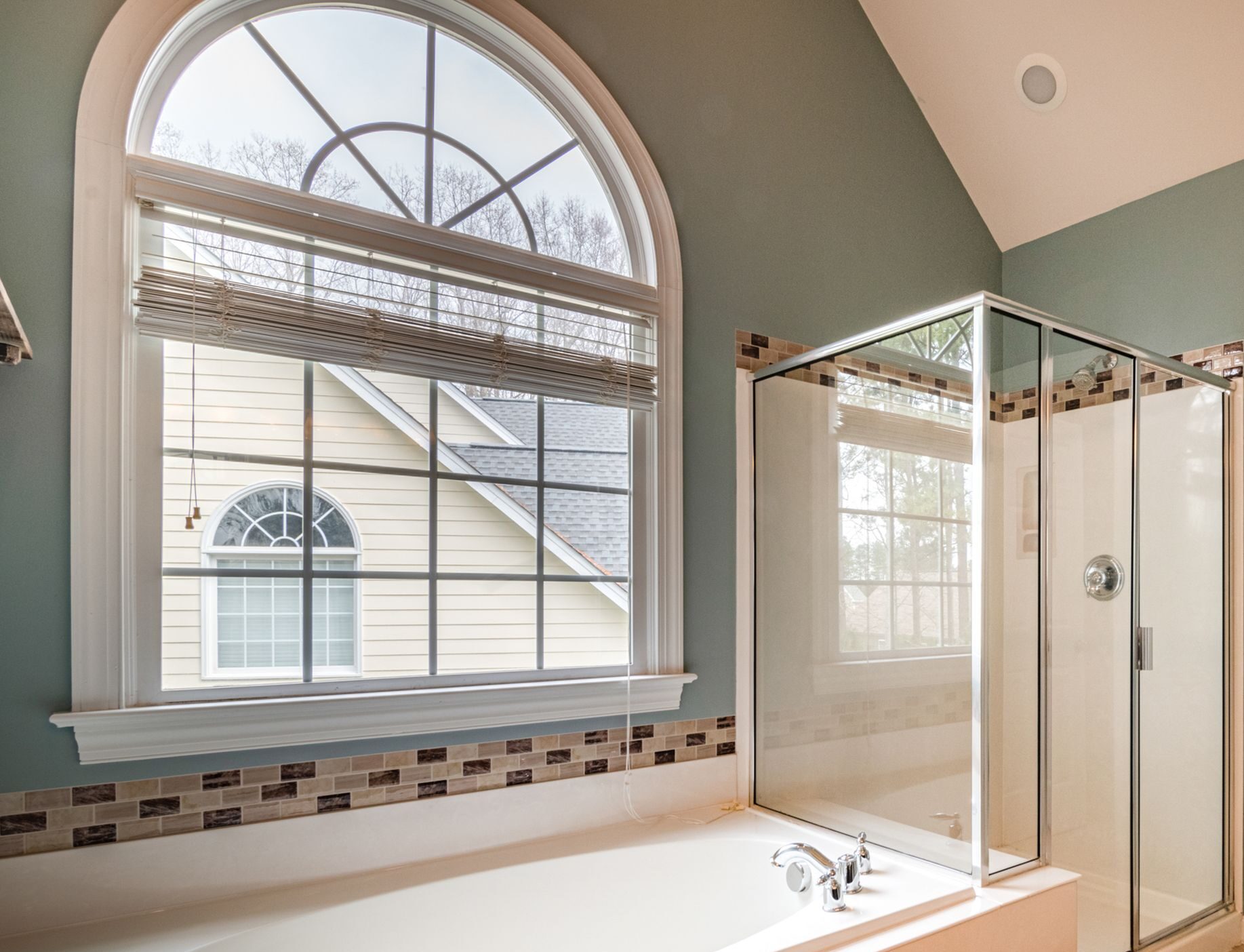 Spacious contemporary bathroom featuring a luxurious bathtub, shower, and adjacent walk-in closet.